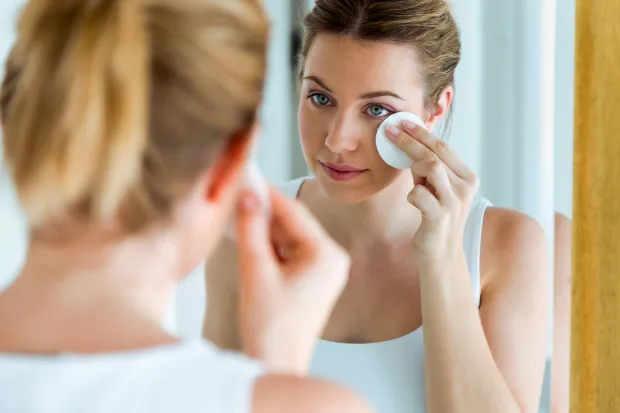 Woman applying toner with a cotton pad in front of mirror - Daily Toner Side Effects: Safe or Harmful Use? 2026 - Zicail Woman applying toner with a cotton pad in front of mirror - Daily Toner Side Effects: Safe or Harmful Use? 2026 - Zicail