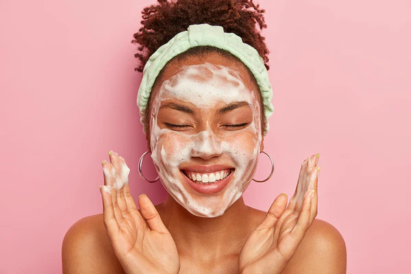 Woman cleansing her face with a gentle foaming cleanser