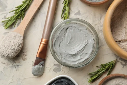 Clay face mask with rosemary and brush on a neutral surface - Waterless Skincare: Benefits, Products & Sustainability - Zicail