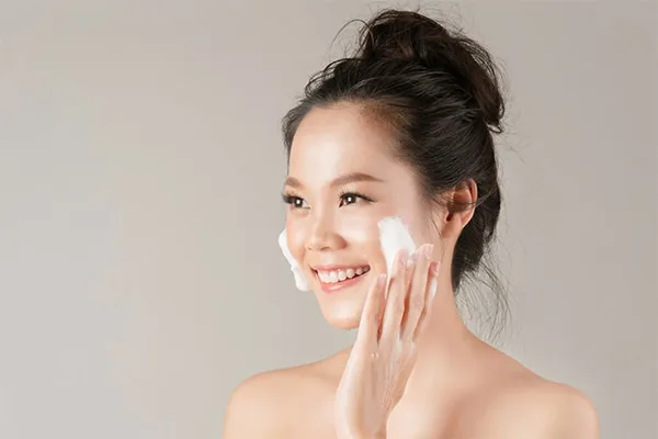 笑顔の女性が顔に泡洗顔料を使っている - 正しい洗顔料の使い方 2026 - Zicail