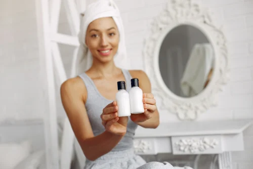 Woman holding two skincare bottles with Snail Mucin products - Snail Mucin in Skincare: Benefits, Usage, and Advice - Zicail