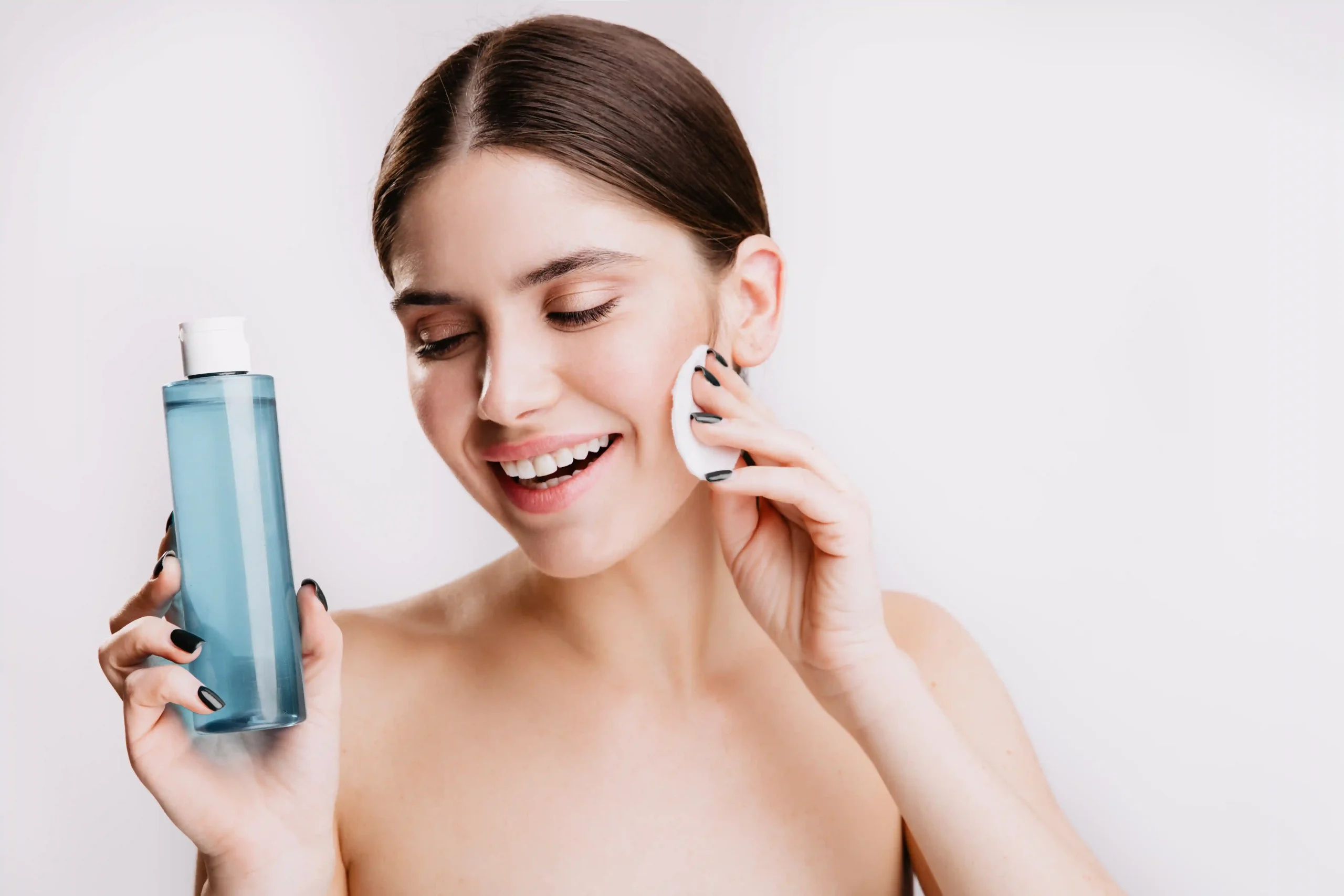 Smiling woman applying toner with a cotton pad - Toner vs Serum: What’s the Difference & Which Do You Need? 2026 - Zicail