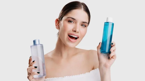 Woman holding two skincare toner bottles and smiling - Toner vs Essence: Differences & Which One You Need - Zicail Woman holding two skincare toner bottles and smiling - Toner vs Essence: Differences & Which One You Need - Zicail