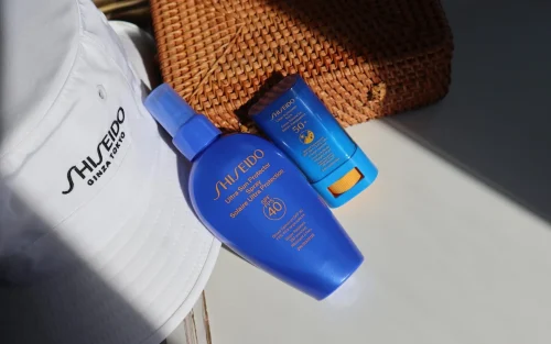 Shiseido sunscreen spray and stick next to a white hat - Sunscreen Stick vs. Spray: Key Differences & Use Cases 2026 - Zicail Shiseido sunscreen spray and stick next to a white hat - Sunscreen Stick vs. Spray: Key Differences & Use Cases 2026 - Zicail