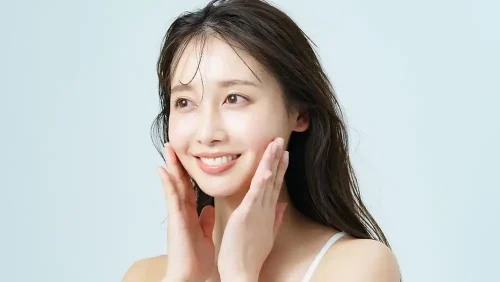 Smiling woman touching her cheeks with both hands - How to Apply Toner Correctly (Step-by-Step Guide) 2026 - Zicail