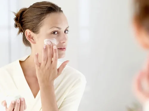 Woman applying cream to her cheek in skincare routine - How to Apply Toner Correctly (Step-by-Step Guide) 2026 - Zicail