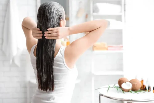 バスルームでヘアマスクを塗る女性 - ヘアマスクとコンディショナー:主な違いとメリットを解説 2026 - Zicail バスルームでヘアマスクを塗る女性 - ヘアマスクとコンディショナー:主な違いとメリットを解説 2026 - Zicail