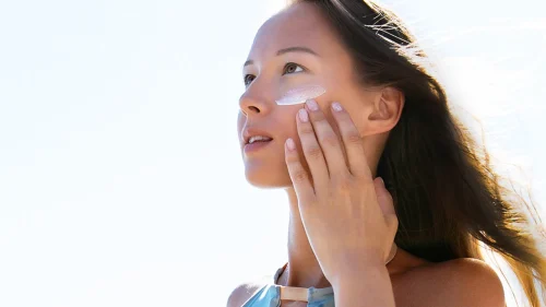 Woman applying sunscreen outdoors on a sunny day - How to Apply Toner Correctly (Step-by-Step Guide) 2026 - Zicail