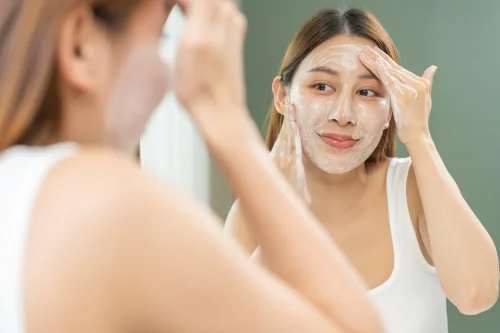 Woman in the mirror applying facial cleanser - Skincare Routine for Dry Skin: How to Start Without Overdoing It 2026 - Zicail Woman in the mirror applying facial cleanser - Skincare Routine for Dry Skin: How to Start Without Overdoing It 2026 - Zicail