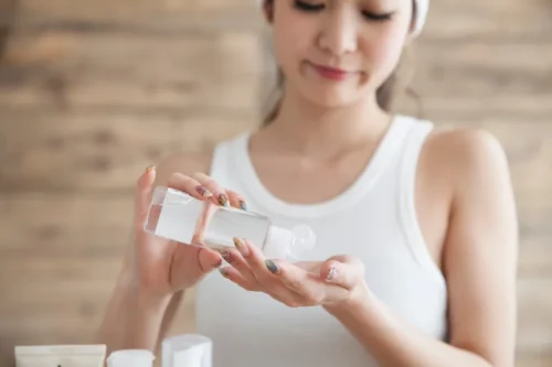 Woman pouring skincare product onto her hand - How to Apply Toner Correctly (Step-by-Step Guide) 2026 - Zicail