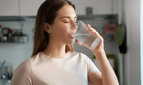 透明なグラスで水を飲む女性。健康な肌のための水分補給を促進 - 滑らかな肌を手に入れる方法:必須のヒントとベストプラクティス 2026 - Zicail 透明なグラスで水を飲む女性。健康な肌のための水分補給を促進 - 滑らかな肌を手に入れる方法:必須のヒントとベストプラクティス 2026 - Zicail