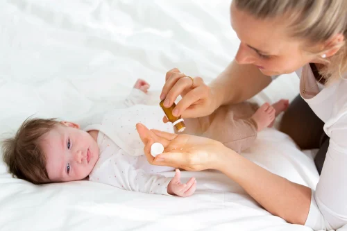 Mother applying oil to her babys hand - Baby Lotion vs Baby Oil: Which Is Best for Your Baby’s Skin? 10月 2026 - Zicail