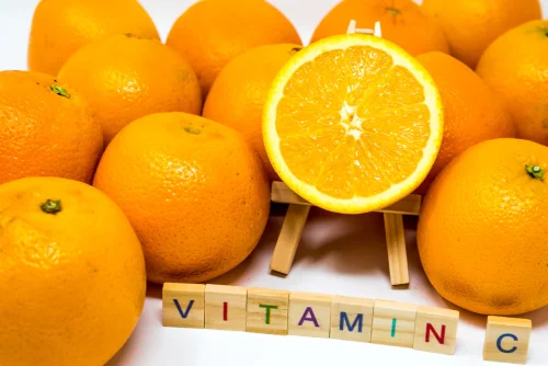 Whole oranges and blocks spelling Vitamin C - How to Use Vitamin C and Hyaluronic Acid Together for Better Skin 2026 - Zicail