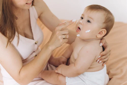 happy mother applying cream her baby girls body face - Baby Lotion vs Baby Oil: Which Is Best for Your Baby’s Skin? 10月 2026 - Zicail