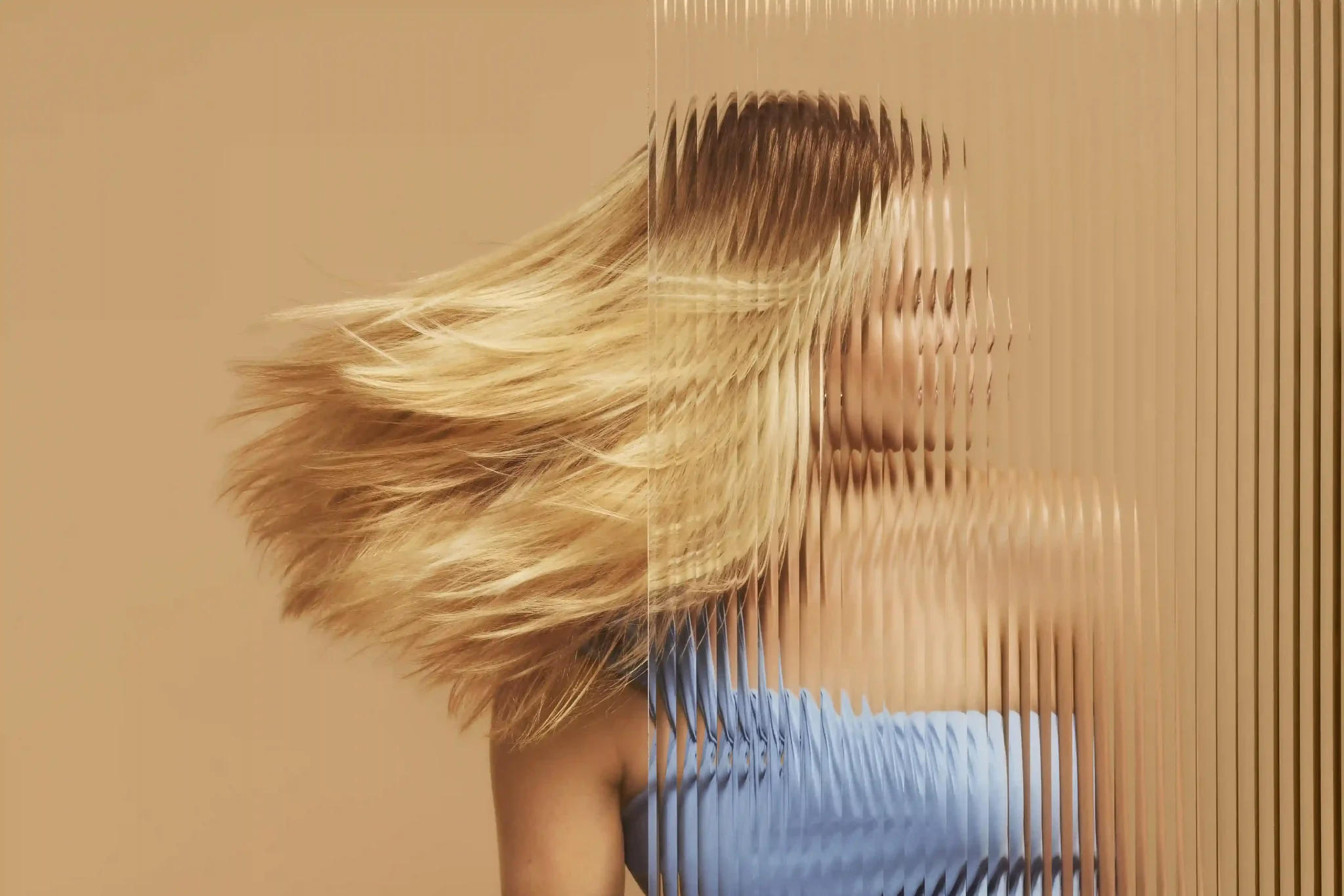 A woman flipping her hair with a blurred effect on the image