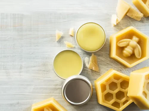 木製の表面に置かれた蜜蝋の缶と型、生の蜜蝋片 - ラノリンは安全ですか?利点、リスク、そして最良の代替品 2026 - Zicail 木製の表面に置かれた蜜蝋の缶と型、生の蜜蝋片 - ラノリンは安全ですか?利点、リスク、そして最良の代替品 2026 - Zicail