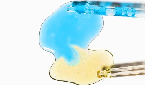 Droplet of blue liquid and yellow serum with hyaluronic acid - How to Layer Hyaluronic Acid and Lactic Acid 2026 - Zicail