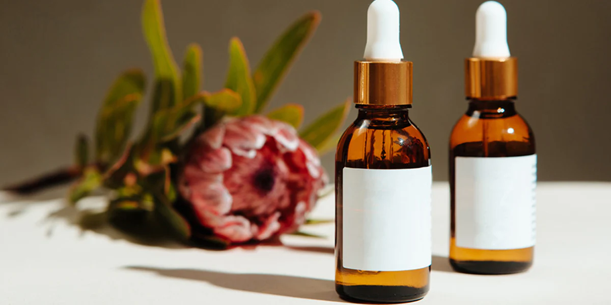 Hair serum bottles with droppers and floral backdrop - Hair Serum vs Hair Oil: Which One Does Your Hair Need? October 2026 - Zicail
