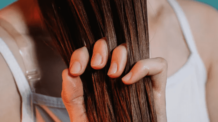 Person applying hair serum to long hair - Hair Serum vs Hair Oil: Which One Does Your Hair Need? October 2026 - Zicail