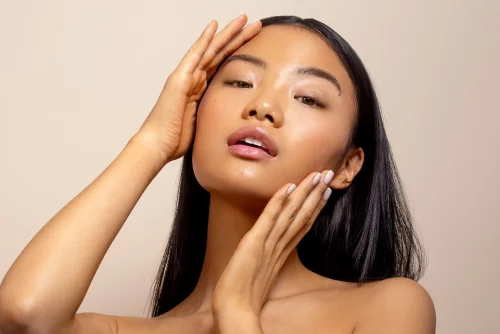 両手で輝くみずみずしい肌に触れる女性 - 自然にみずみずしい肌を手に入れる方法:メイク不要!2026 - Zicail 両手で輝くみずみずしい肌に触れる女性 - 自然にみずみずしい肌を手に入れる方法:メイク不要!2026 - Zicail