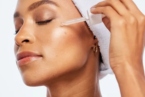 Woman with a dropper bottle featuring Hyaluronic Acid - How to Use Vitamin C and Hyaluronic Acid Together for Better Skin 2026 - Zicail