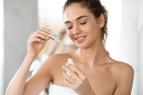 Woman with a dropper bottle featuring Hyaluronic Acid - How to Use Vitamin C and Hyaluronic Acid Together for Better Skin 2026 - Zicail