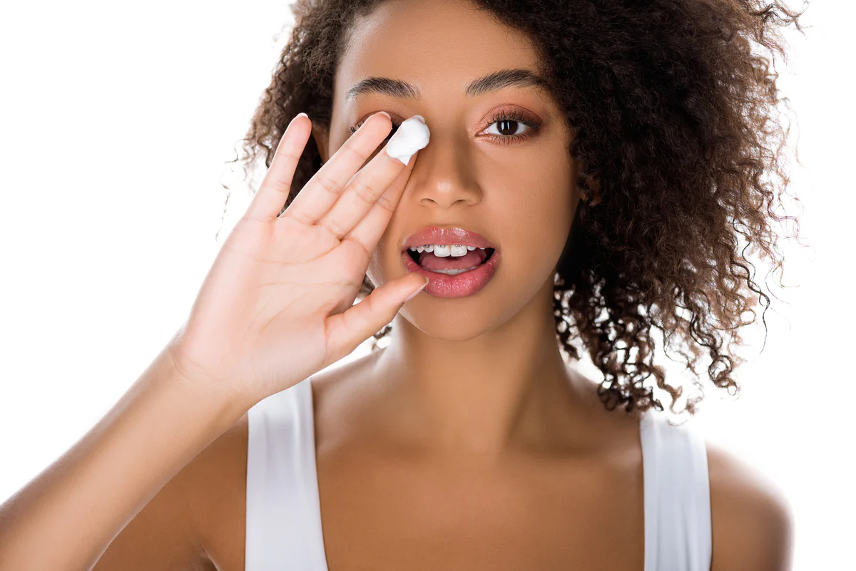Woman with afro applying cream for spring skincare - How to Layer Skincare: A Rule-Based Guide to Correct Order 2026 - Zicail
