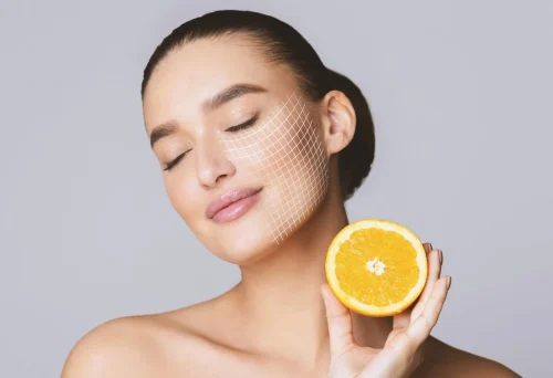 A woman joyfully holds an orange slice to her face symbolizing vitamin C - Is Vitamin C Good Under Makeup? Tips for Glowing Skin 2026 - Zicail