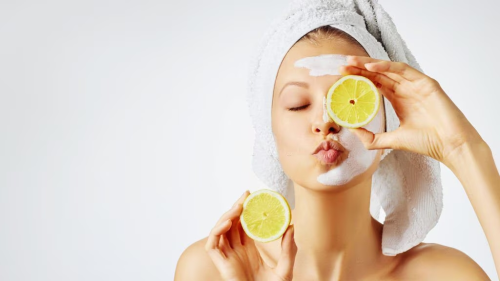 A woman with a towel on her head holds a lemon slice symbolizing vitamin C - Is Vitamin C Good Under Makeup? Tips for Glowing Skin 2026 - Zicail