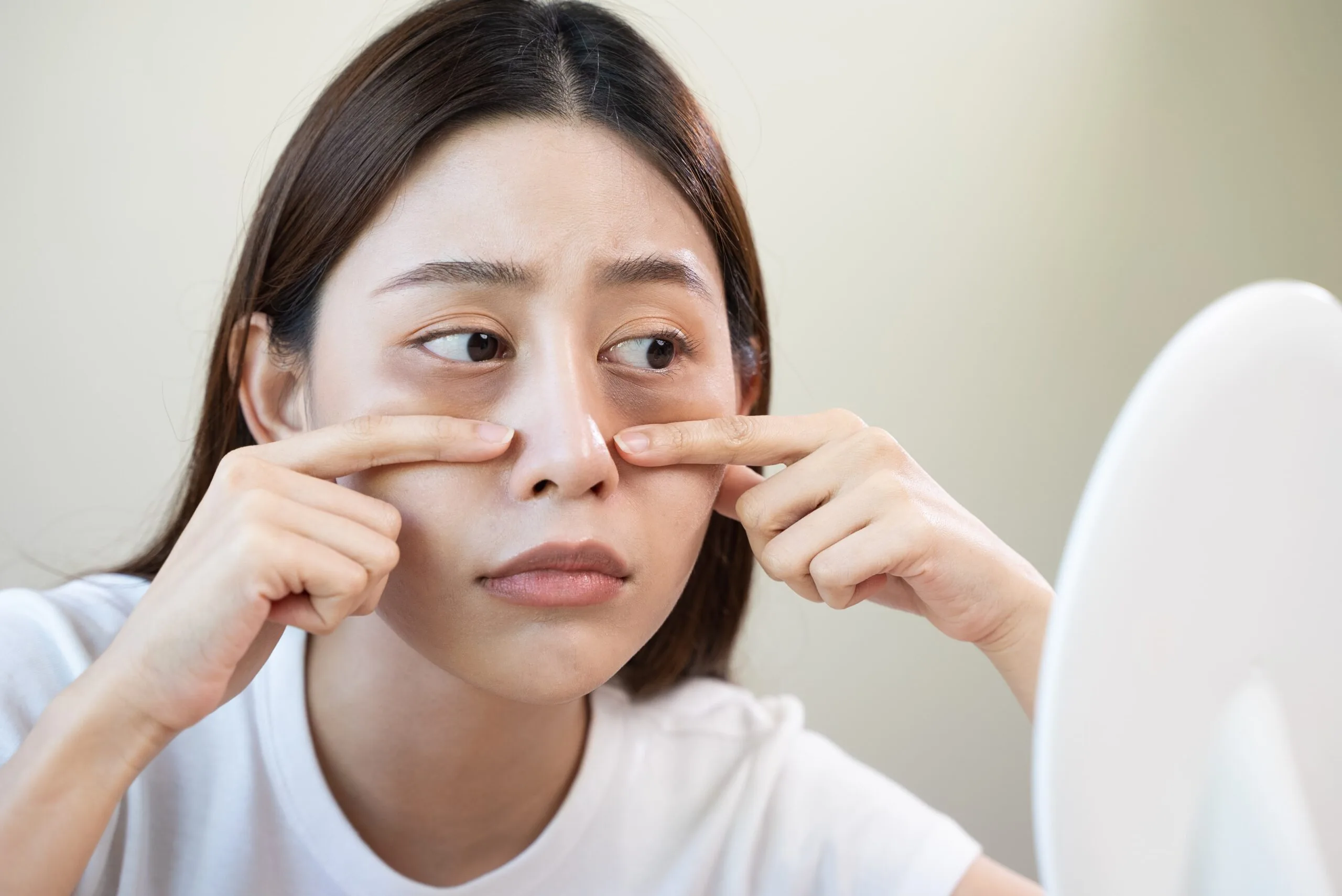 Woman checking eye bags in mirror - How to Get Rid of Bags Under the Eyes 2026 - Zicail