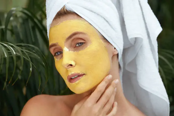 A close up of a woman with a turmeric face mask looking relaxed - Turmeric for Skin: Benefits, Uses, and Safety Tips 2026 - Zicail