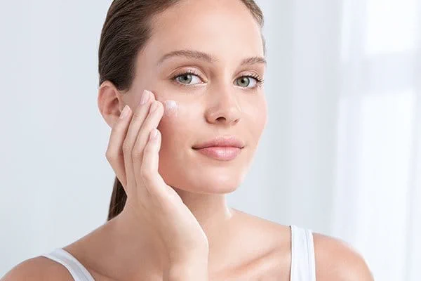 A woman gently applying Vitamin F infused serum to her face - Vitamin F for Skin: Benefits & How to Use in Skincare 2026 - Zicail