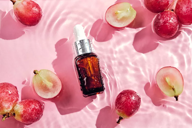 Grapeseed oil dropper on water with red grapes - Grapeseed Oil for Skin: Benefits & How to Use 2026 - Zicail