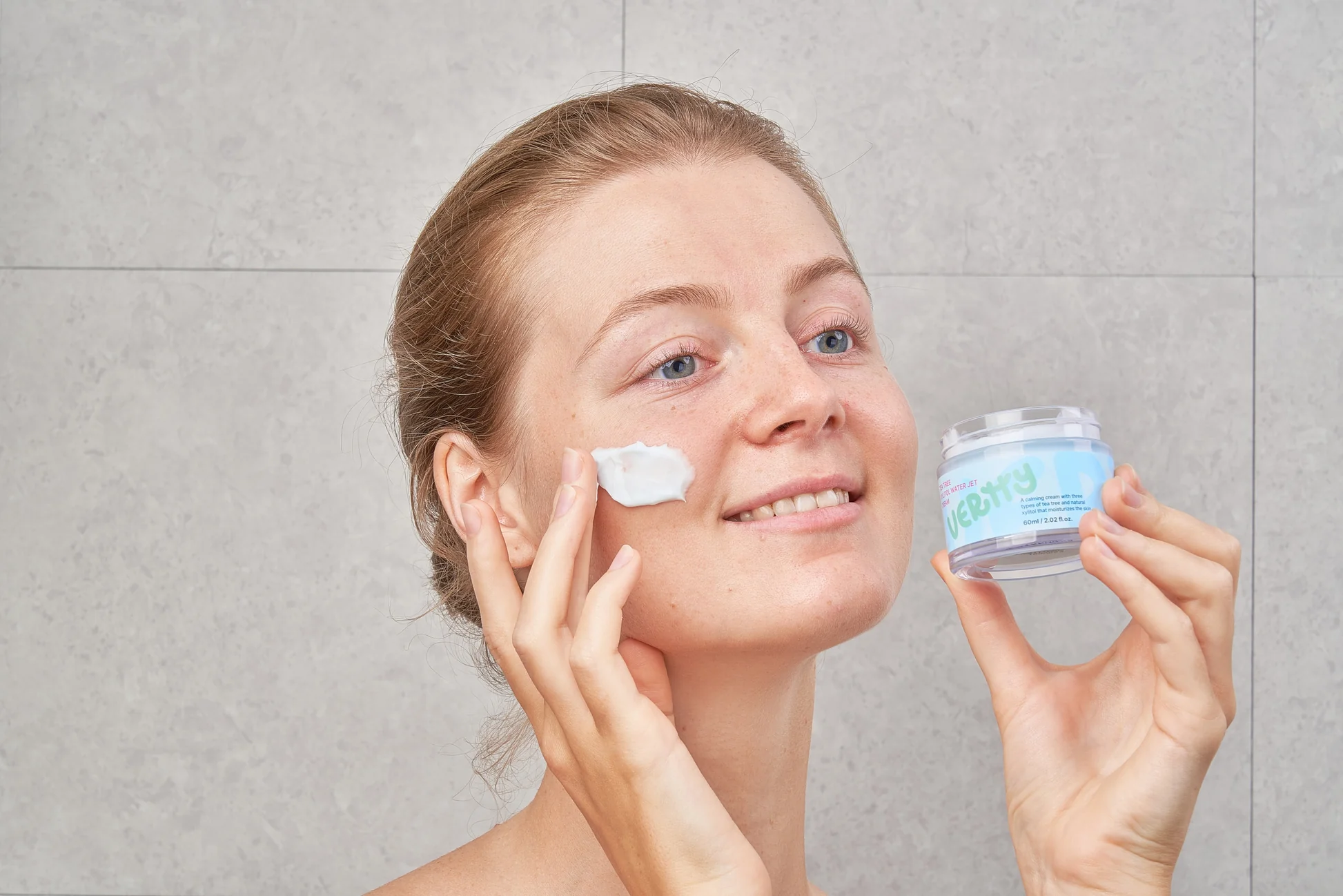 Smiling woman applying cream on her skin - Xylitol in Skincare: Hydration, Benefits & Uses Explained 2026 - Zicail
