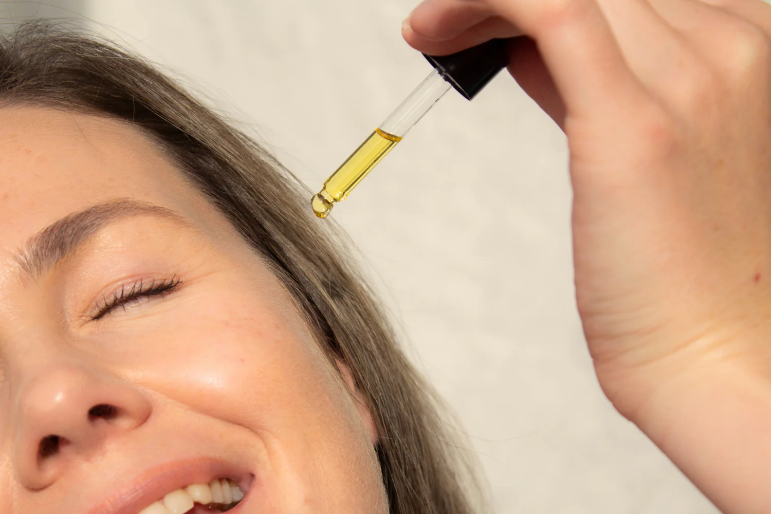 A woman applying facial oil with a dropper enhancing skin care - Soybean Oil for Skin: Benefits, Uses & Precautions 2026 - Zicail A woman applying facial oil with a dropper enhancing skin care - Soybean Oil for Skin: Benefits, Uses & Precautions 2026 - Zicail