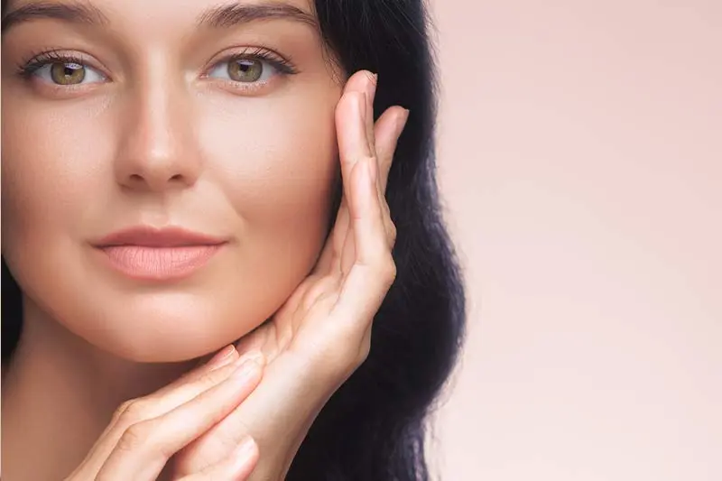 A woman gently touching her smooth radiant face showcasing healthy skin - Oleic Acid for Skin: Benefits, Risks & Best Oils 2026 - Zicail A woman gently touching her smooth radiant face showcasing healthy skin - Oleic Acid for Skin: Benefits, Risks & Best Oils 2026 - Zicail