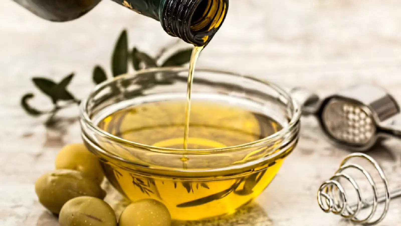 Olive oil being poured into a bowl a natural source of oleic acid for skin hydration - Oleic Acid for Skin: Benefits, Risks & Best Oils 2026 - Zicail Olive oil being poured into a bowl a natural source of oleic acid for skin hydration - Oleic Acid for Skin: Benefits, Risks & Best Oils 2026 - Zicail