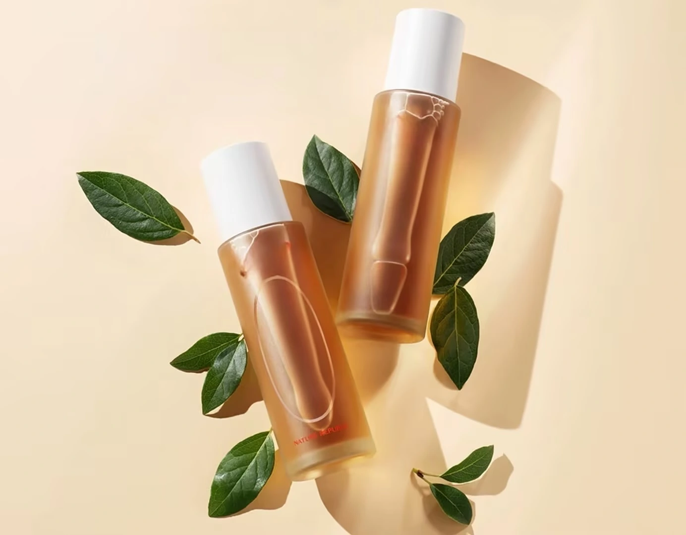 Two kombucha skincare essence bottles with green leaves - Kombucha for Skin: Complete Benefits Guide 2026 - Zicail Two kombucha skincare essence bottles with green leaves - Kombucha for Skin: Complete Benefits Guide 2026 - Zicail