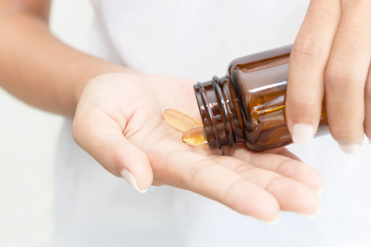 A person pouring linoleic acid soft gel capsules into their hand - Linoleic Acid for Skin: Benefits, Sources & Tips 2026 - Zicail A person pouring linoleic acid soft gel capsules into their hand - Linoleic Acid for Skin: Benefits, Sources & Tips 2026 - Zicail
