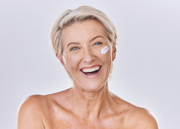Mature woman with cream shows caffeic acid in skincare - Caffeic Acid in Skincare: Benefits & How to Use 2026 - Zicail