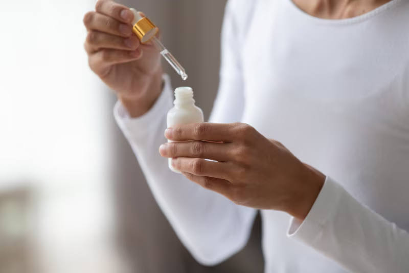 Woman holding dropper bottle of polyhydroxy acids for skin - Polyhydroxy Acid in Skincare: Benefits, Uses, and How It Works 2026 - Zicail Woman holding dropper bottle of polyhydroxy acids for skin - Polyhydroxy Acid in Skincare: Benefits, Uses, and How It Works 2026 - Zicail