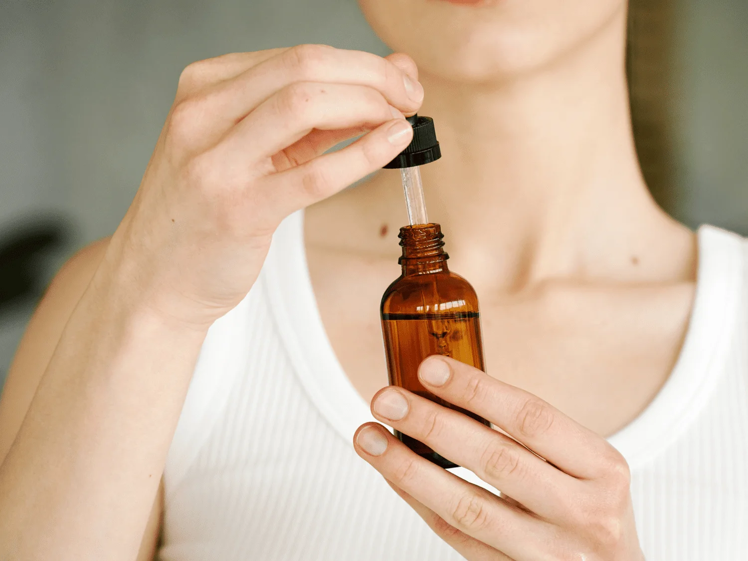 Woman holding dropper bottle of pyruvic acid for skin use - Pyruvic Acid for Skin: Benefits, Use & Safety Guide 2026 - Zicail