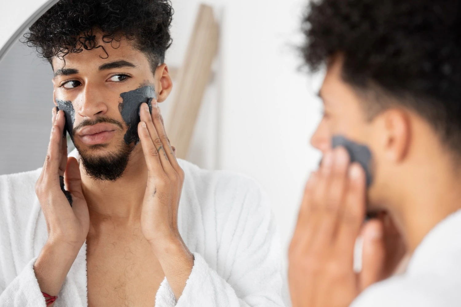 自宅で炭のフェイスマスクを塗る男性。ディープクレンジングと皮脂コントロールのためのメンズスキンケアルーティンの一環 - 男性に最適なスキンケアルーティンとは?2026 - Zicail 自宅で炭のフェイスマスクを塗る男性。ディープクレンジングと皮脂コントロールのためのメンズスキンケアルーティンの一環 - 男性に最適なスキンケアルーティンとは?2026 - Zicail